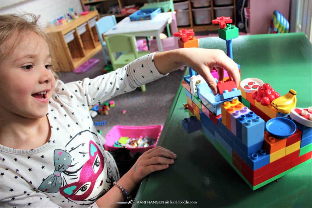 little girl makiing lego duplo vehicle