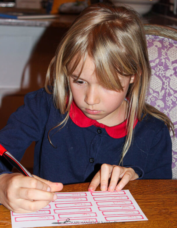 girl writing on stamped labels