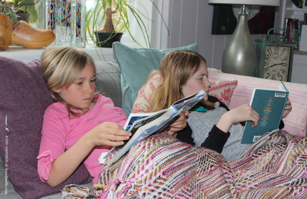 2 girls reading on sofa