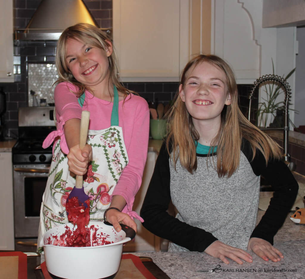 2 girls happily making cookies