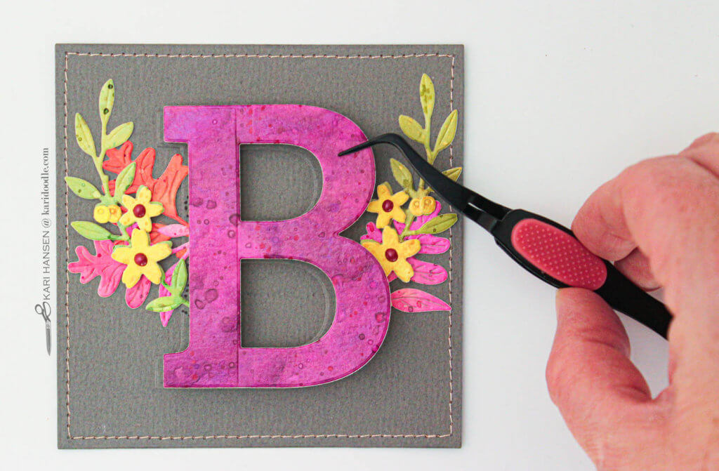 using tweezers to place letter B on monogram card